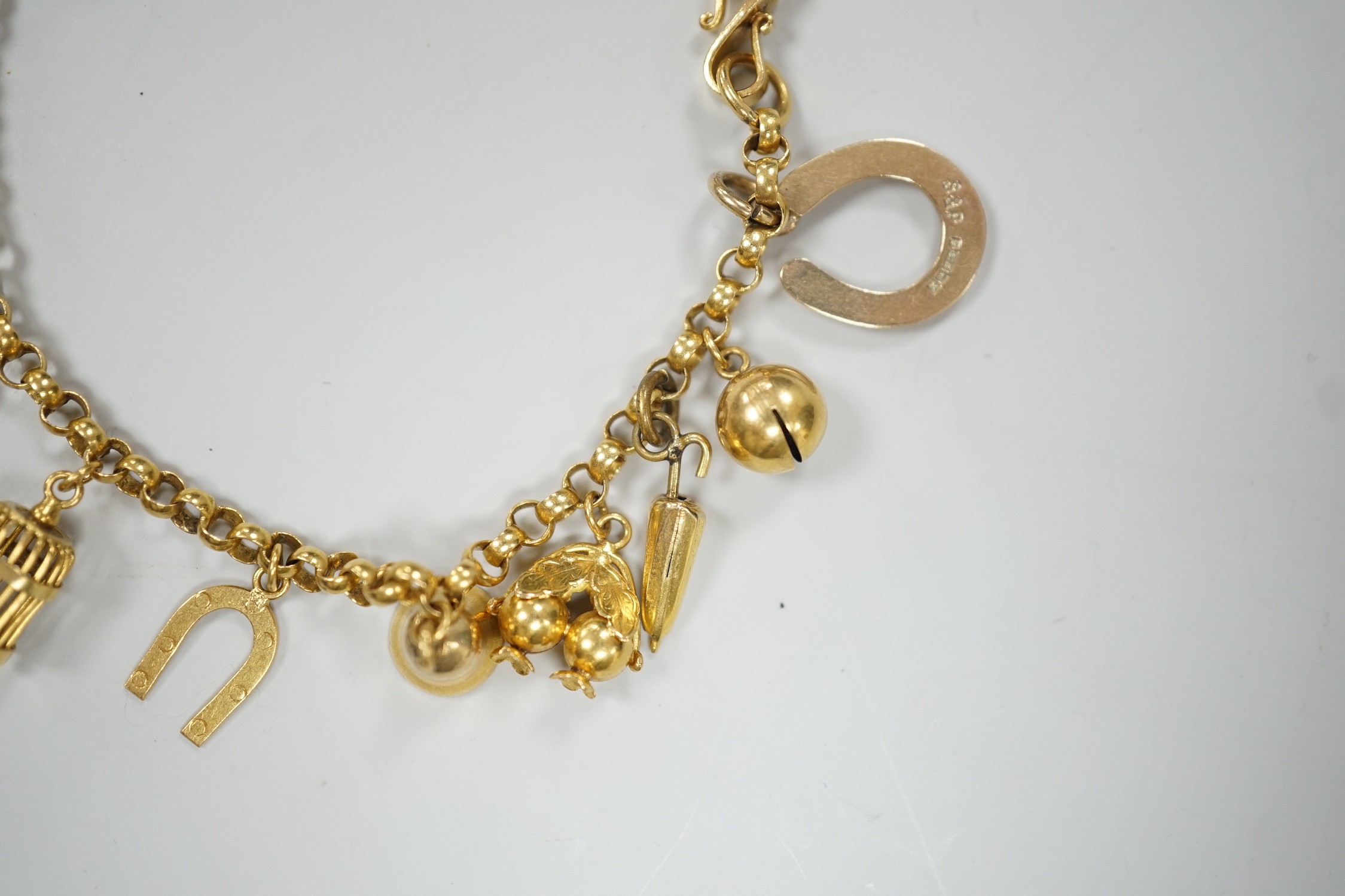 A Chinese yellow metal charm bracelet, hung with thirteen assorted yellow metal charms including four 9ct, 15.5cm